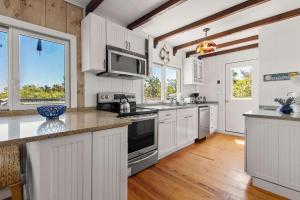a kitchen with white cabinets and white appliances at Walk to Oceanside Beach in Wellfleet