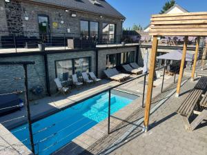 a swimming pool with chairs and a house at Durbuy House in Durbuy