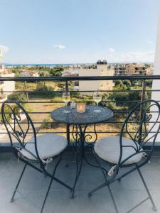a table and chairs on a balcony with a view at Comfy Vista Apartment in Kalamata