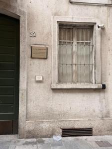 a building with a window and a sign on it at Appartamento centro parma con ascensore BORGO 22 in Parma