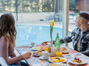 a man and woman sitting at a table eating breakfast at Novotel Roma Est in Rome