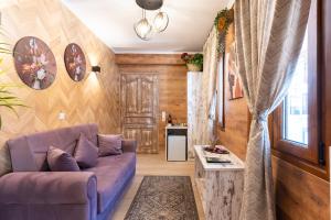 a living room with a purple couch and a table at Lume in Metsovo