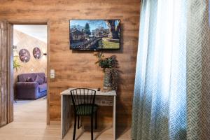 a room with a table and a tv on a wall at Lume in Metsovo +6 photos