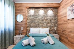 a bedroom with a blue bed with two pillows at Lume in Metsovo
