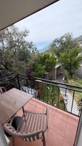 a balcony with a wooden table and a bench at Dhoma Elena in Dhërmi +36 photos