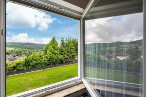 a window with a view of a green field at Fewo zum Eisenstollen in Balve