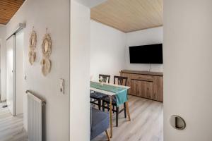 a dining room with a table and a flat screen tv at Fewo zum Eisenstollen in Balve