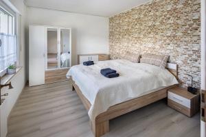 a bedroom with a large bed with a brick wall at Fewo zum Eisenstollen in Balve