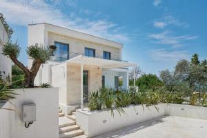 a white house with plants in front of it at White Pearl Villa in Tivat +40 photos