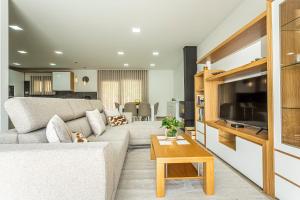 a living room with a couch and a tv at Casa Manecas by Hostiva in Reriz