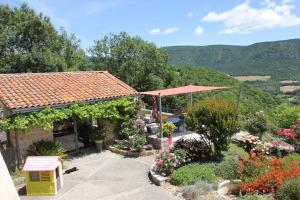 a house with a garden with flowers and a roof at Le clair de lune in Millau +7 photos