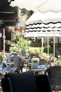 an outdoor cafe with tables and chairs and an umbrella at Le Mirabeau Resort & Spa in Zermatt