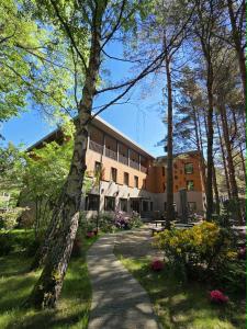 a building with a pathway in front of a building at Gintarautojai in Palanga