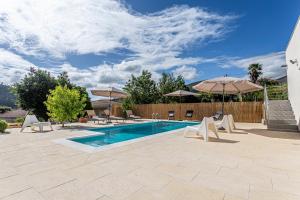a pool with chairs and umbrellas on a patio at Casa Manecas by Hostiva in Reriz