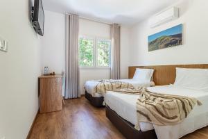 two beds in a room with white walls and wooden floors at Casa Manecas by Hostiva in Reriz +52 photos