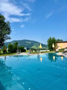 a large swimming pool with blue water at Vitalhotel Quellengarten - Bed & Breakfast in Lingenau