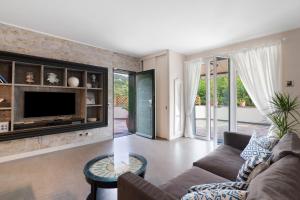 a living room with a couch and a tv at Casa Due Ulivi in Lavagna