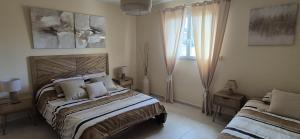 a bedroom with two beds and a window at Une Belle Histoire in Argelliers