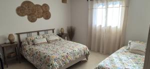 a bedroom with two beds and a window at Une Belle Histoire in Argelliers +1 photo
