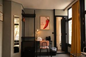een kamer met een bureau, een stoel en een raam bij The Saints Sutor Hotel in Breda