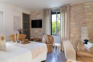 a bedroom with a bed and a table and chairs at Le Mas du Terme in Barjac
