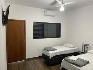 a room with two beds and a television on the wall at CMS PLAZA Hotel in Serrana