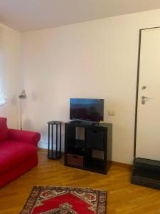 a living room with a red couch and a flat screen tv at La casa di Giulia in Genoa