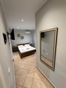 a bedroom with a bed and a mirror on the wall at Dhoma Elena in Dhërmi