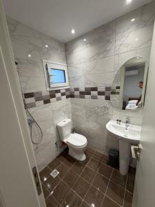 a bathroom with a toilet and a sink at Dhoma Elena in Dhërmi