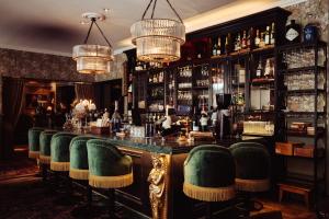 a bar with green chairs in a room at Hotel Pigalle in Gothenburg