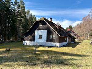 a large wooden house in the middle of a field at Apartmány Polná na Šumavě in Svíba