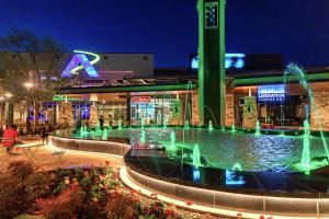 a fountain in front of a building at night at Excel Grand Stays in Frisco +4 photos