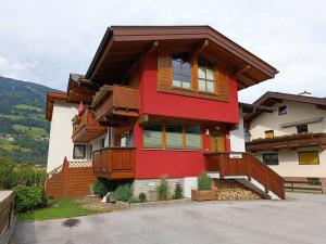 a red and white house with wooden balconies at Ferienwohnung Magdalena in Stumm