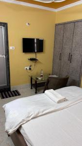 a bedroom with a bed and a desk and a tv at Hotel Surbhi in Shaikhpura