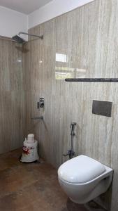 a bathroom with a white toilet and a shower at Hotel Surbhi in Shaikhpura