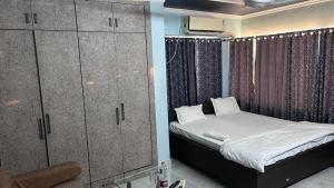 a small bedroom with a bed and a cabinet at Hotel Surbhi in Shaikhpura