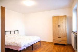 a bedroom with a bed and a wooden cabinet at La Dimora del Cadore in Domegge di Cadore