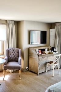 a living room with a chair and a television at Lebeaubylivingroom Hotel in Knokke-Heist