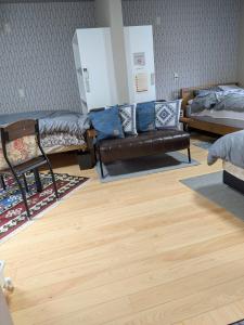 a room with a couch and a bed and wooden floors at Kumanokodo KURA in Shingū