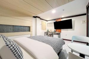 a hotel room with a bed and a tv at Ramon Hotel in Seoul +14 photos