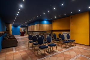 a waiting room with chairs and a couch and a bar at Hotel Ransol in El Tarter