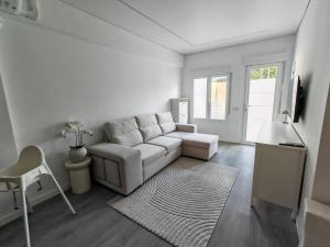 a white living room with a couch and a table at La Romanilla Garden terrace in Roquetas de Mar