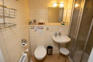 a bathroom with a toilet and a sink and a shower at Appartementhaus Anne in Binz +37 photos