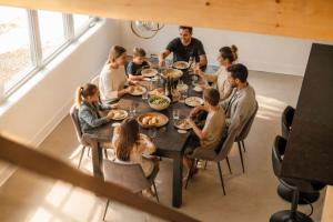 a group of people sitting around a table eating food at Spa & Lake - Orphee in Chertsey