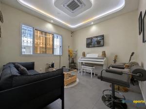 a living room with a couch and a piano at Chic apart with parking and balcony in Yaoundé