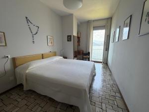 a bedroom with a white bed and a window at Villa 64 in Fiumelatte