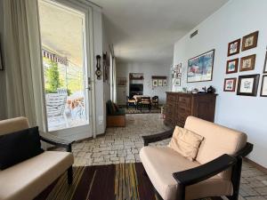 a living room with two chairs and a couch at Villa 64 in Fiumelatte