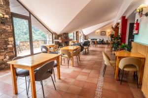 a restaurant with tables and chairs and a large window at Hotel Ransol in El Tarter