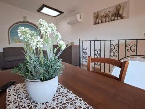 a vase with white flowers on a wooden table at Casa Sant'Antonio in Orosei