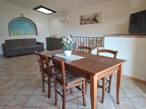 a kitchen and dining room with a wooden table and chairs at Casa Sant'Antonio in Orosei +23 photos
